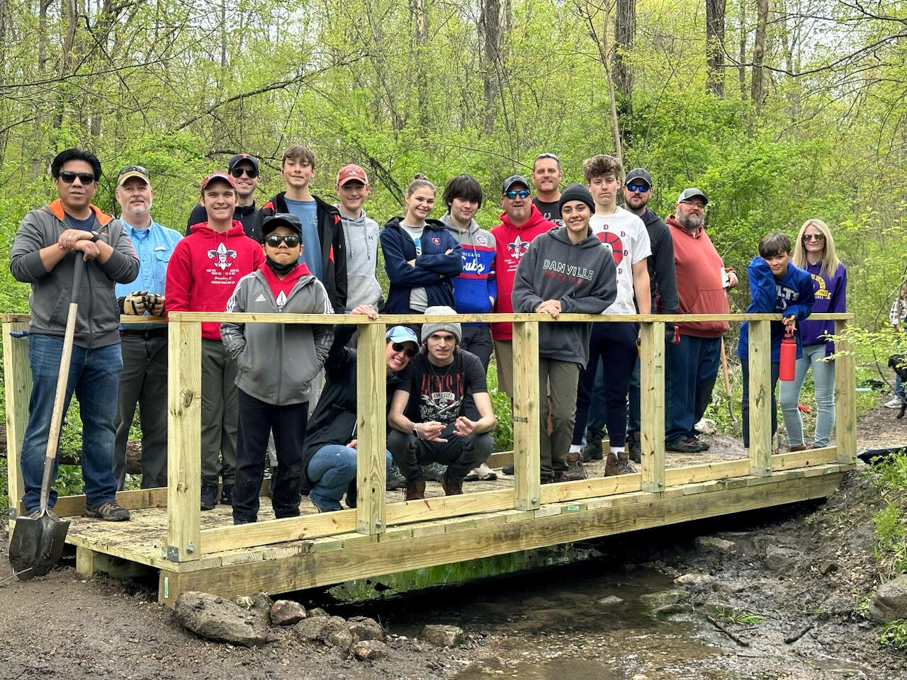 Group standing on newly built bridge over stream crossing